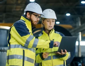 techniciens terrain qui discutent avec ordinateur portable à la main