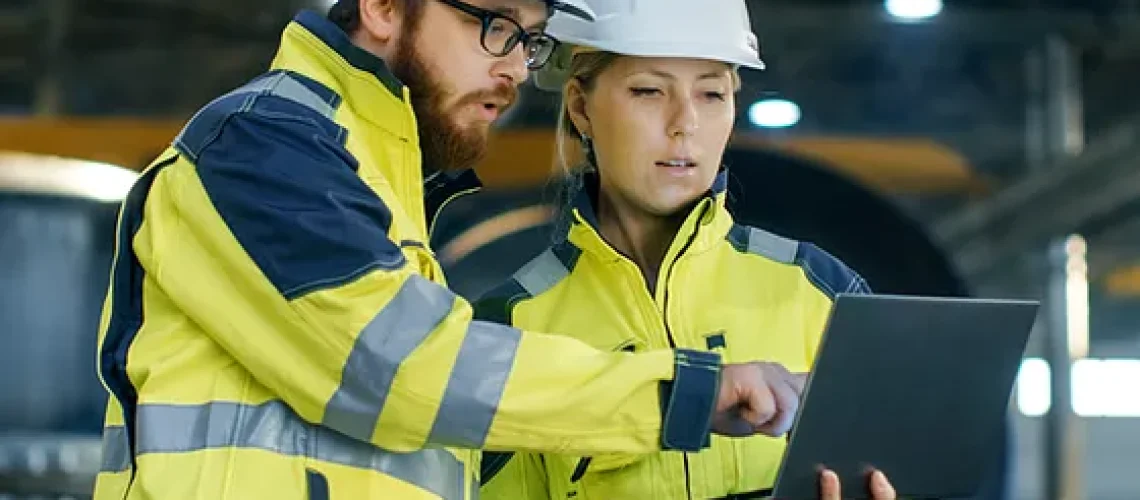 techniciens terrain qui discutent avec ordinateur portable à la main